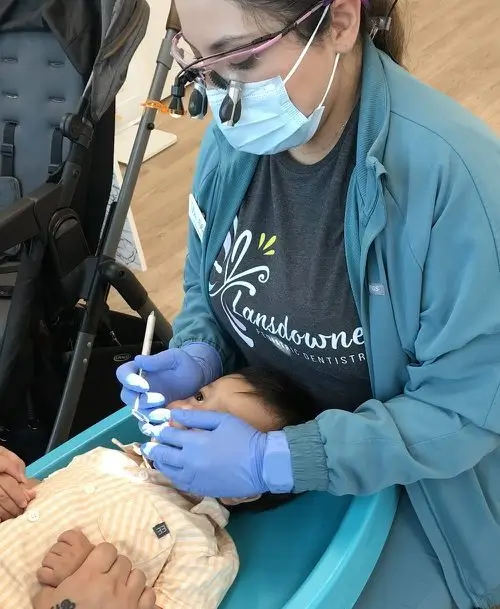 a woman wearing a mask and gloves holding a baby